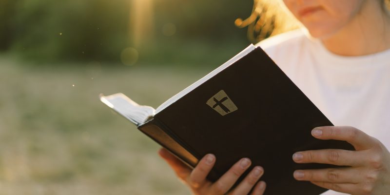 Christian woman holds bible in her hands.